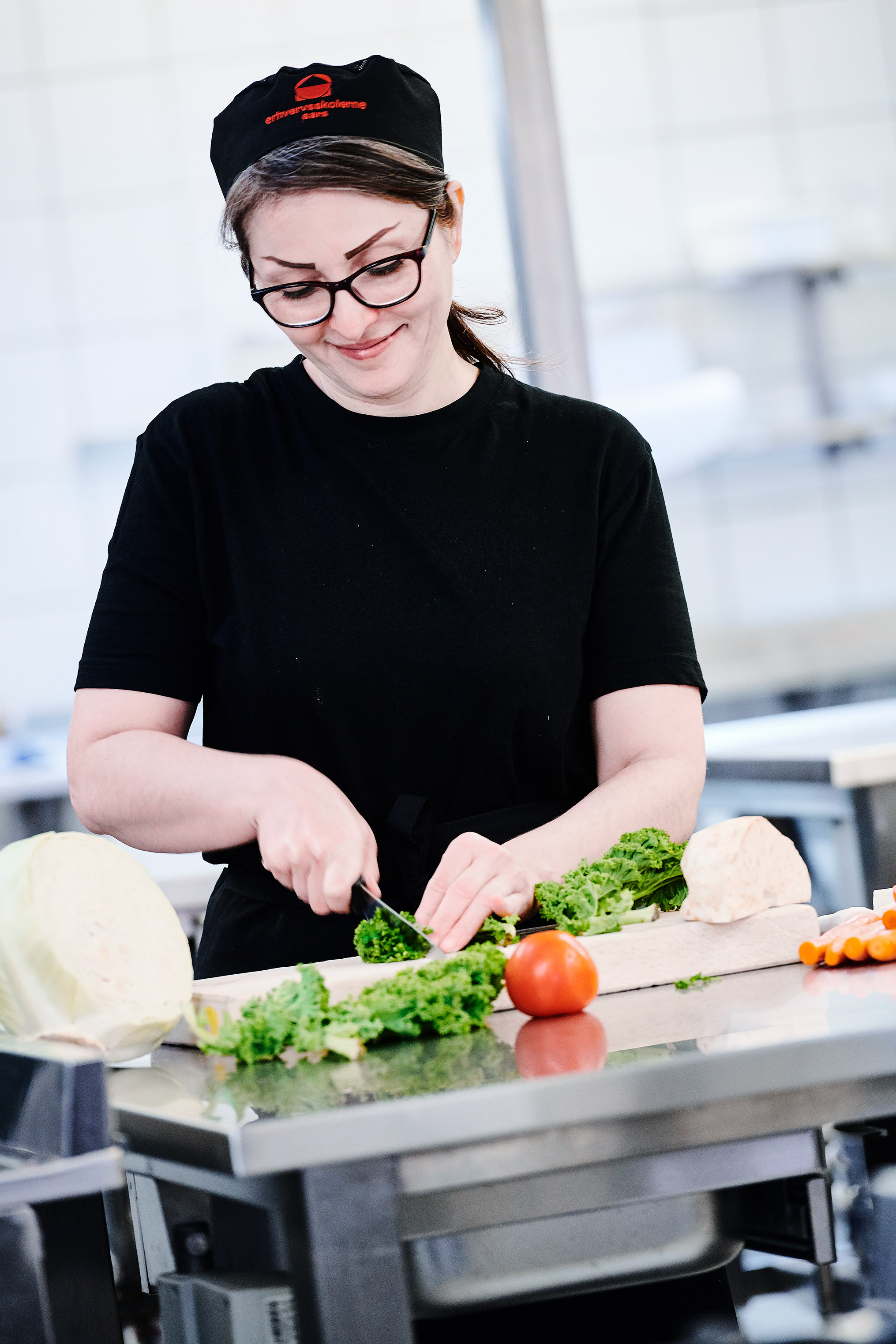 Elev fra uddannelsen fødevarer, jordbrug og oplevelser i gang med at skære grøntsager