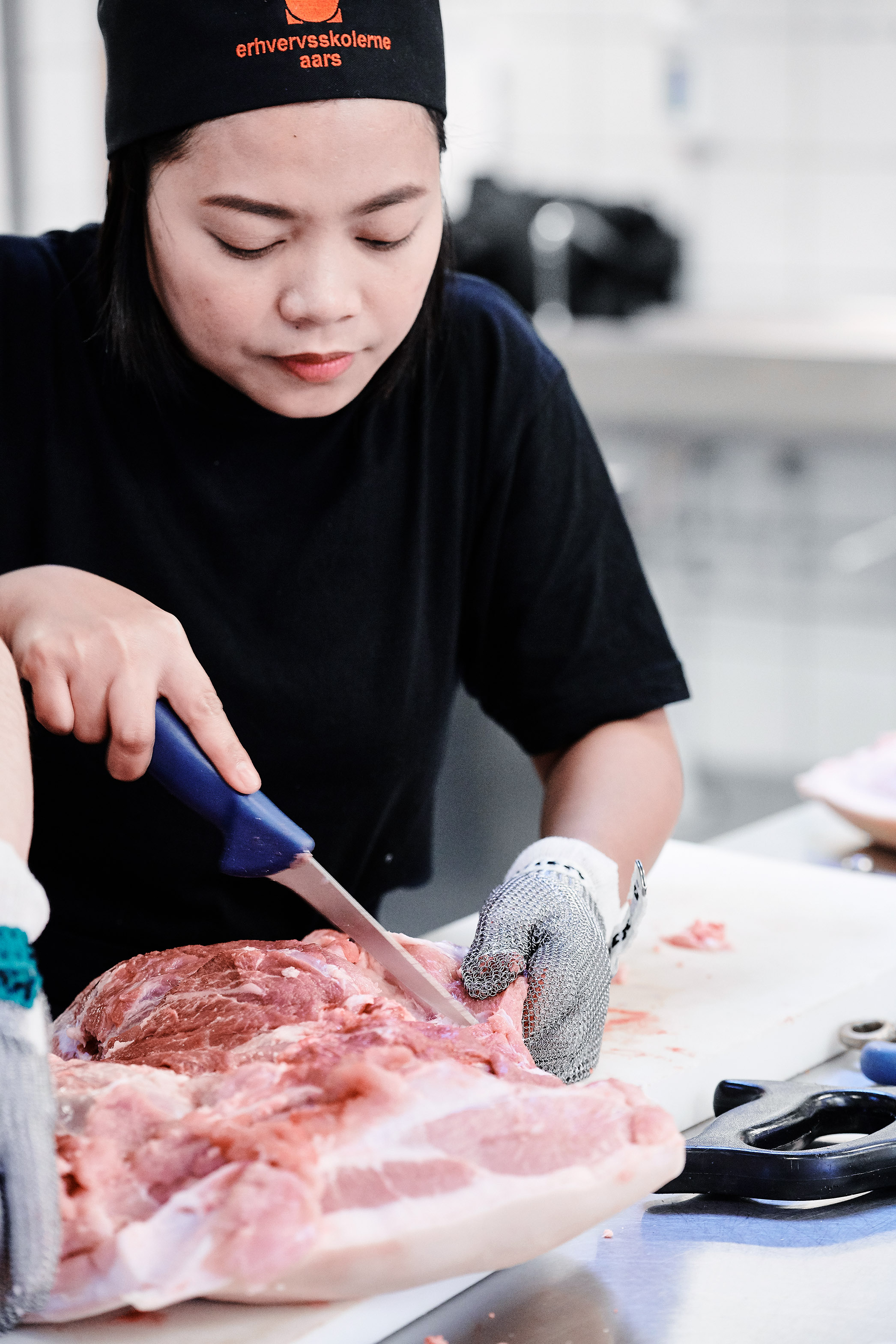 Elev fra uddannelsen fødevarer, jordbrug og oplevelser i gang med udskæring af kød