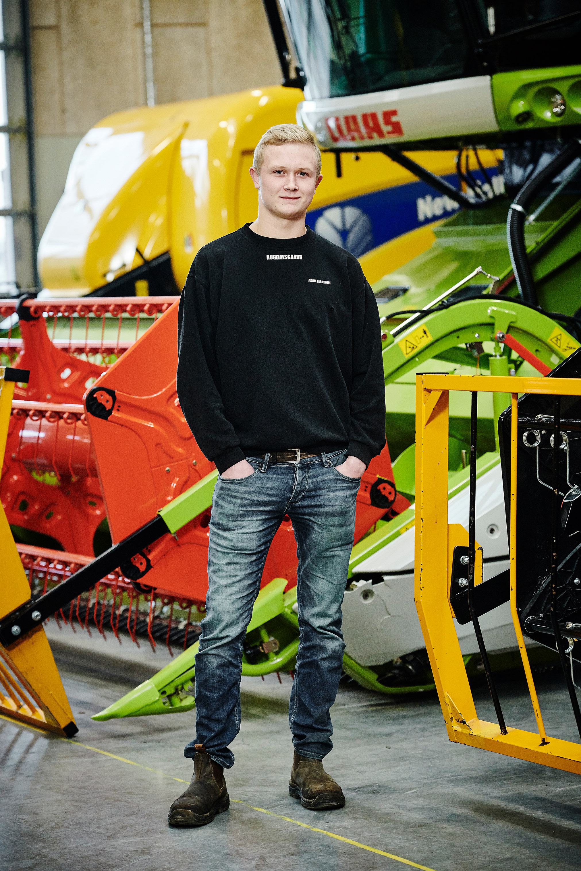 Elev fra entreprenør- og landbrugsmaskinuddannelsen foran de store landbrugsmaskiner