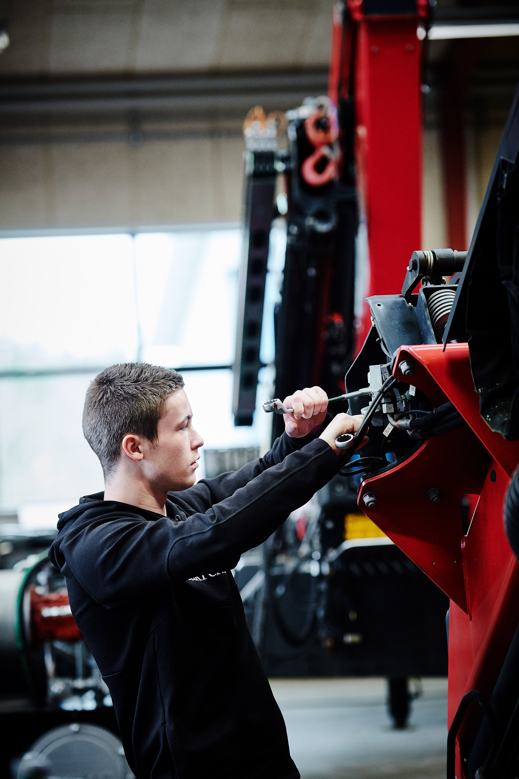 Elev fra entreprenør- og landbrugsmaskinuddannelsen i gang med at reparere på en maskine