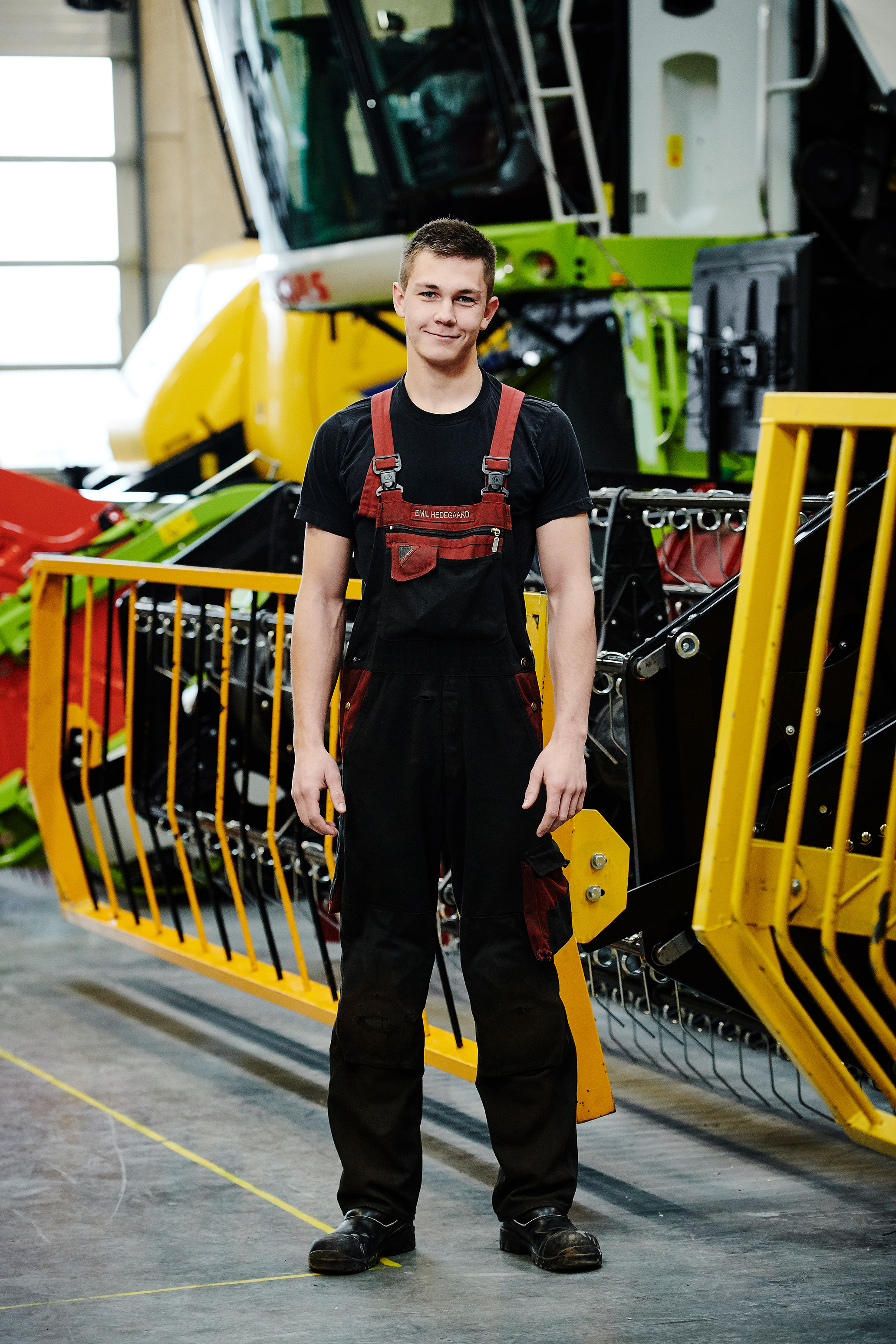 Elev fra entreprenør- og landbrugsmaskinuddannelsen foran de store landbrugsmaskiner