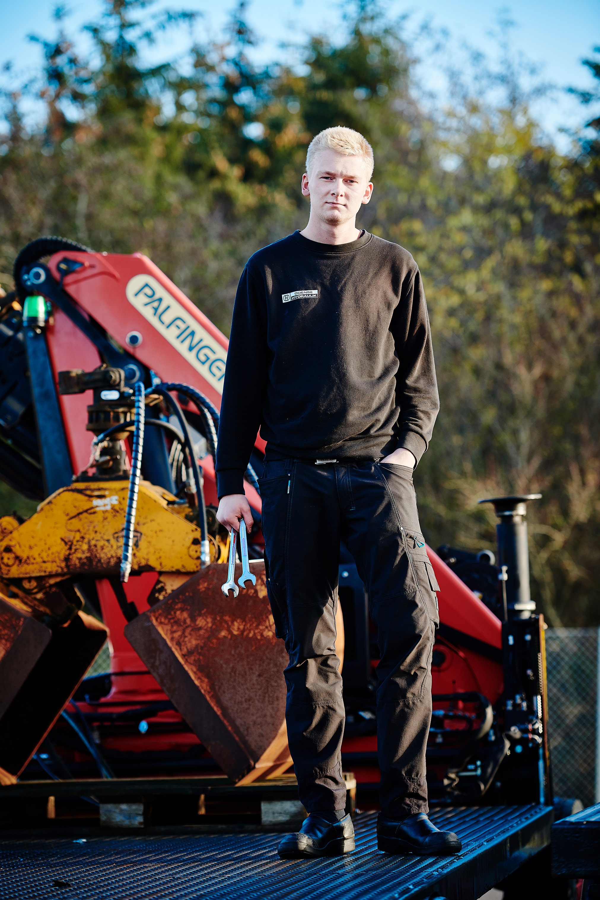 Elev fra entreprenør- og landbrugsmaskinuddannelsen foran en kran
