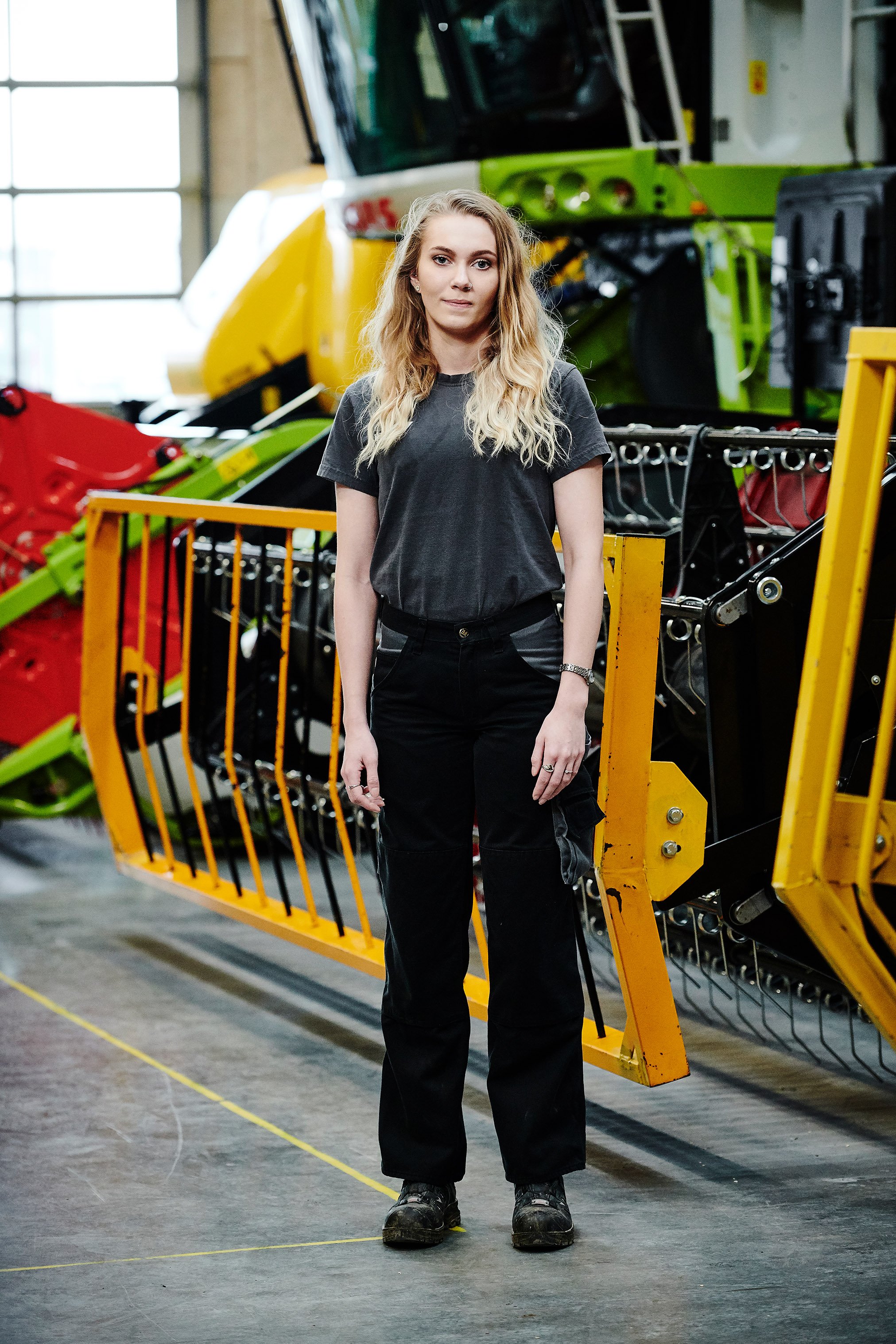 Elev fra entreprenør- og landbrugsmaskinuddannelsen foran de store landbrugsmaskiner