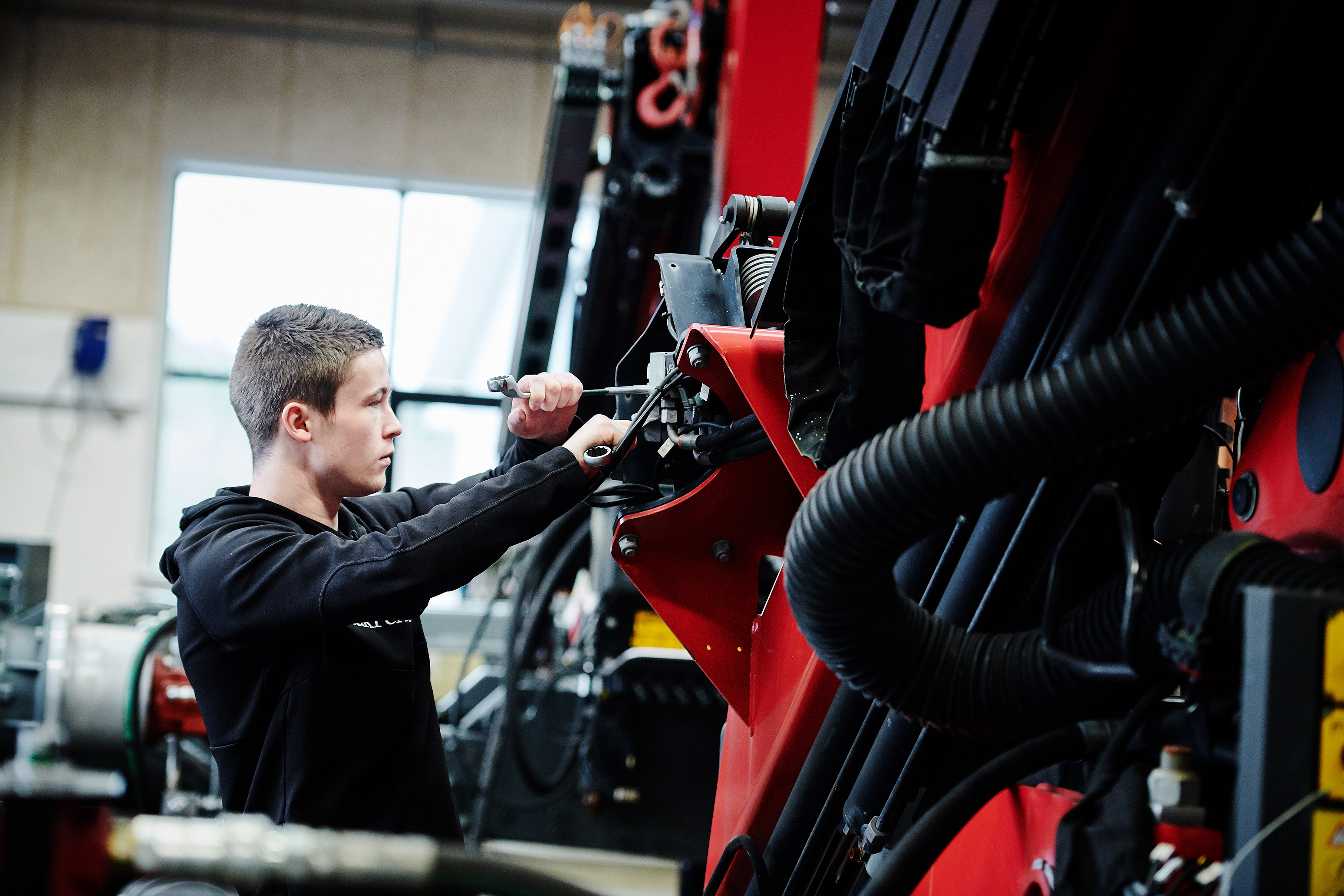 Elev fra entreprenør- og landbrugsmaskinuddannelsen i gang med at kigge på en maskine