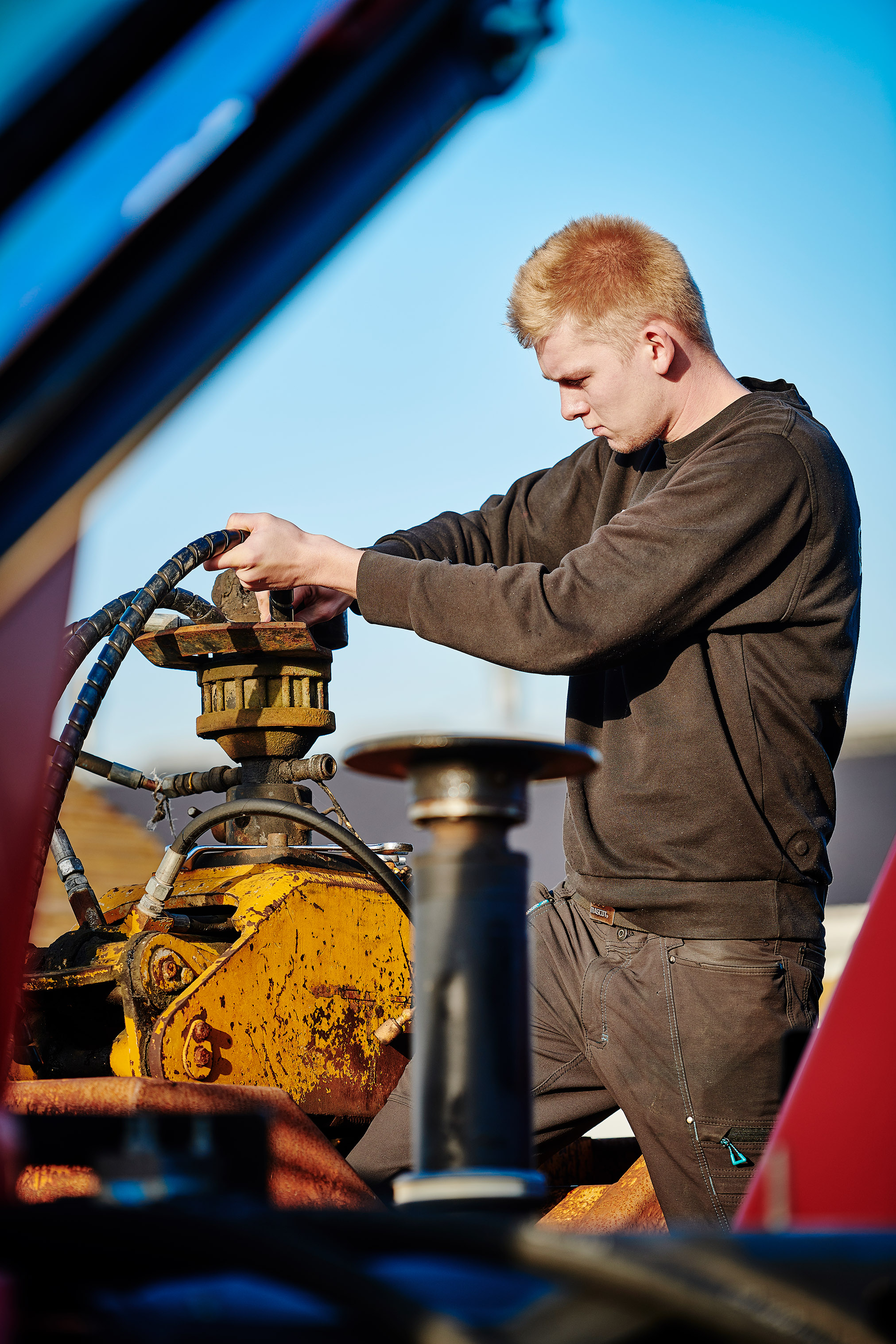 Elev fra entreprenør- og landbrugsmaskinuddannelsen i gang med at reparere en maskine