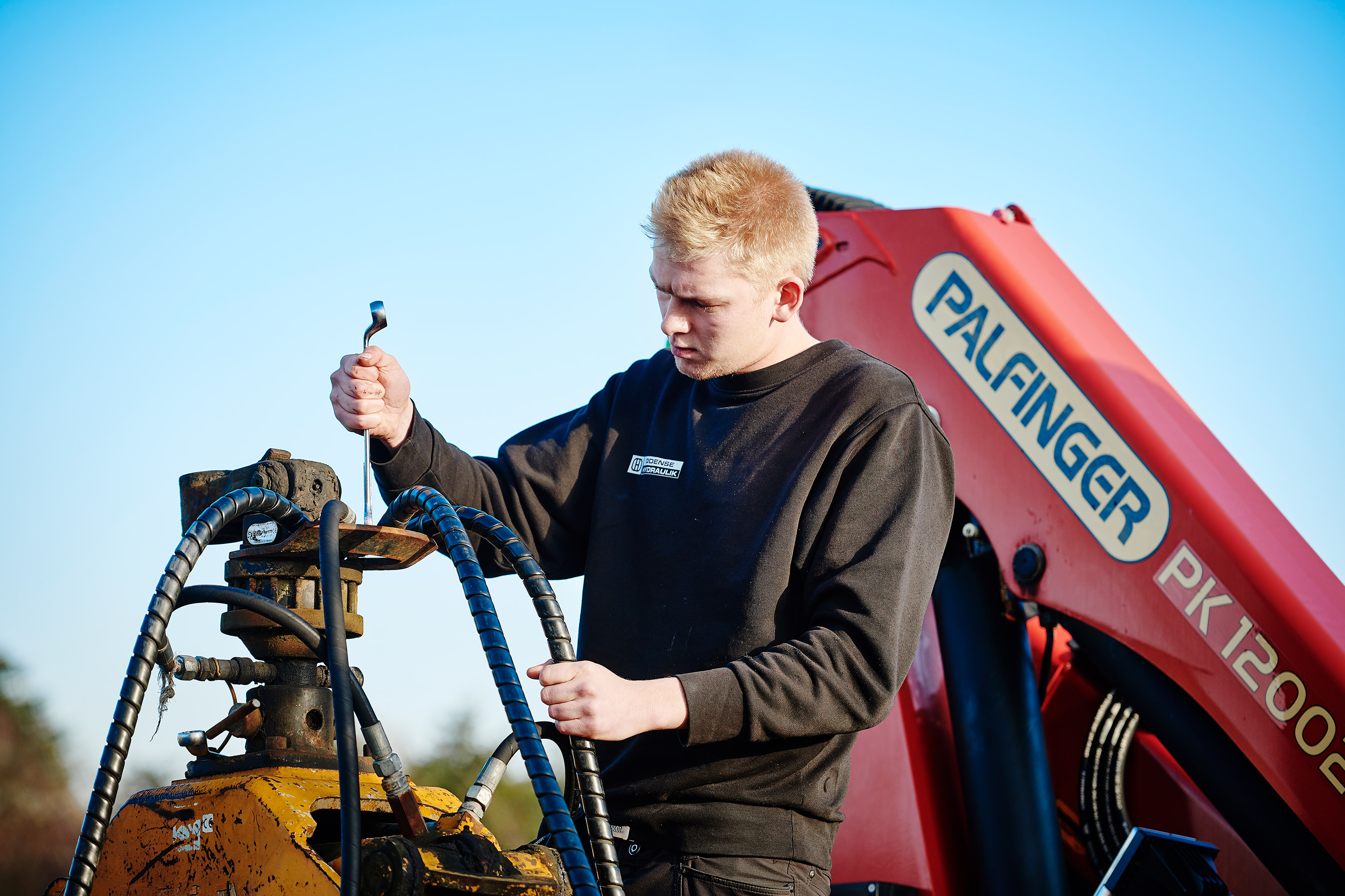 Elev fra Entreprenør- og landbrugsmaskinuddannelsen i gang med at reparere en maskine