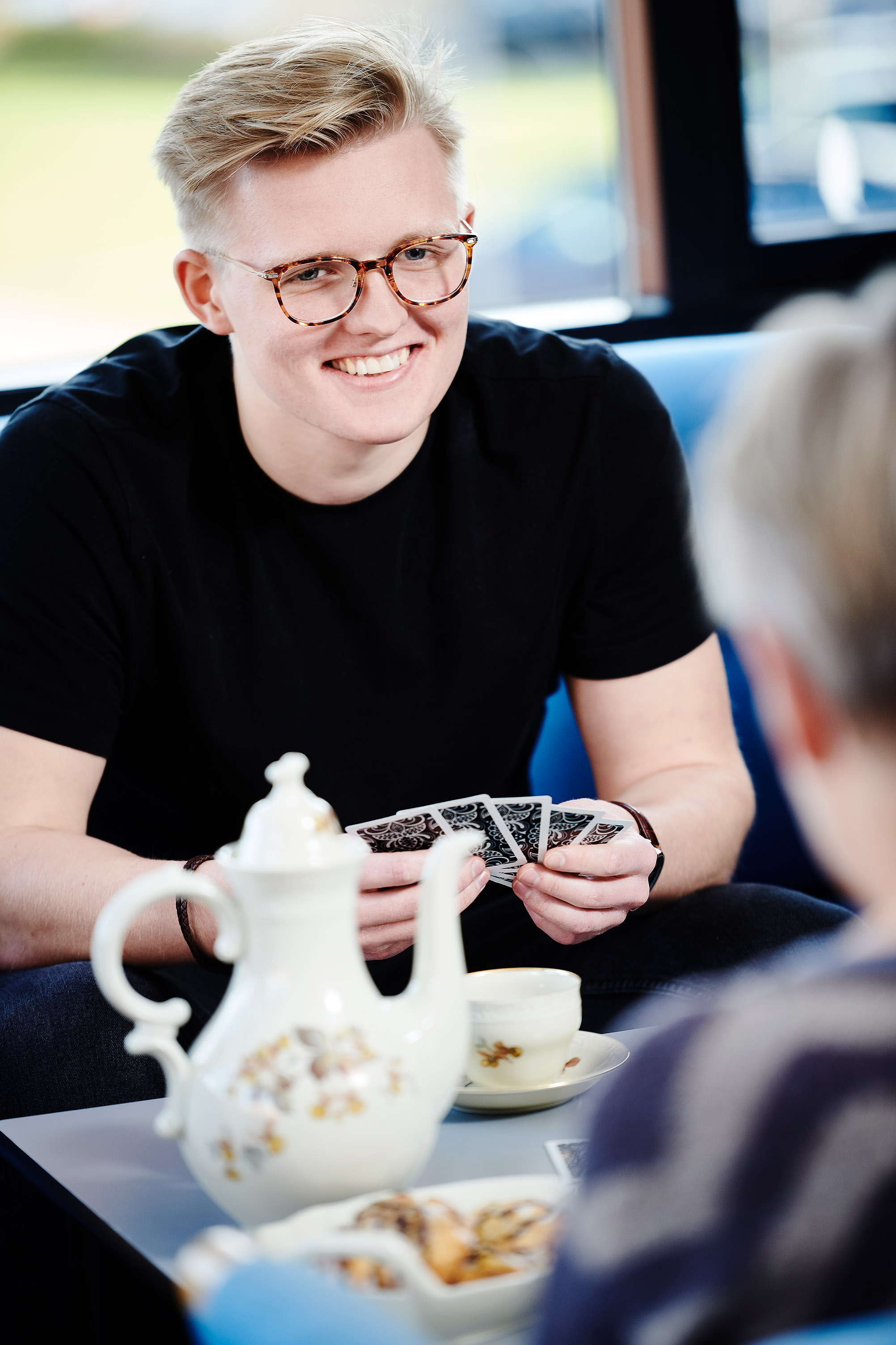 En ung Sosu elev tager en pause med kortspil og kaffe